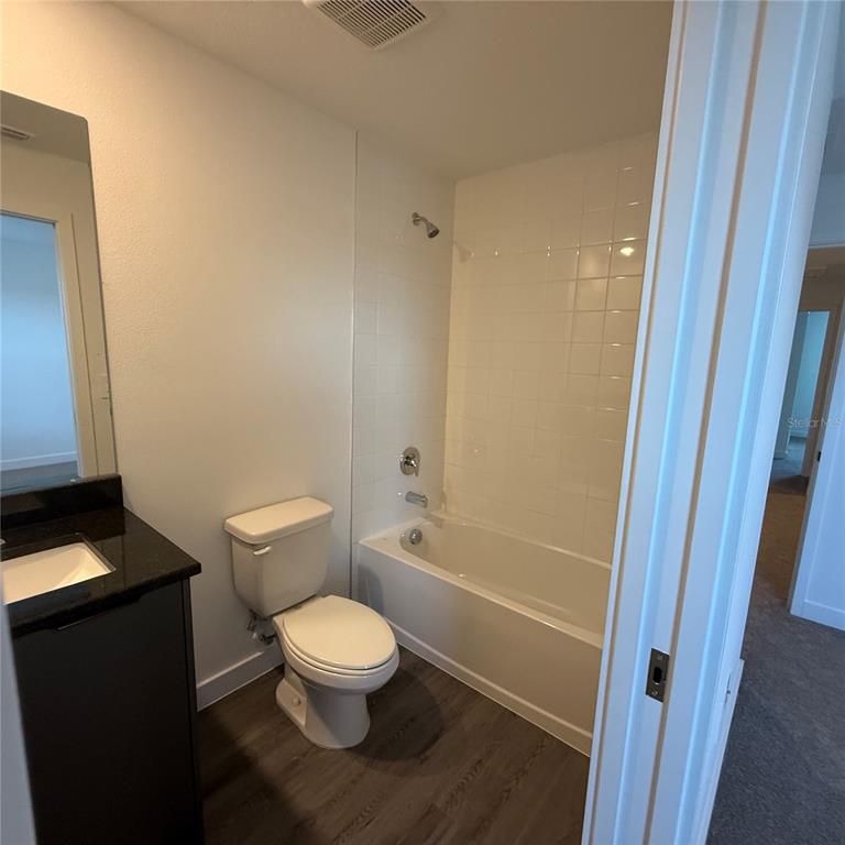 3245 Sustainable Way Kissimmee, FL 34747 - Photo 20 of 35 a white toilet sitting next to a bathroom sink