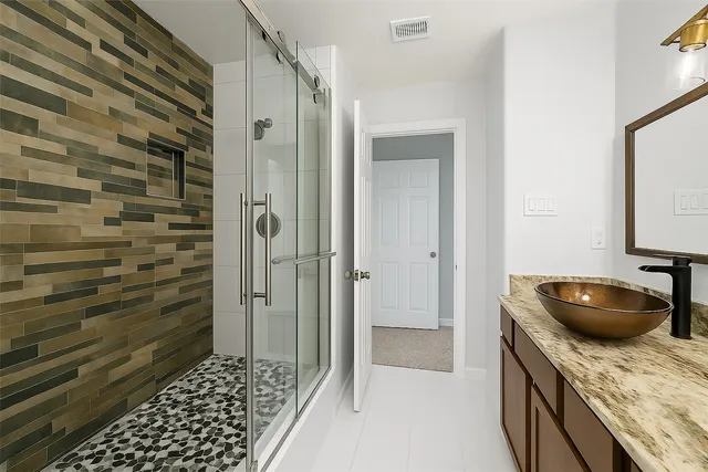 a bathroom with a granite countertop sink a toilet and shower