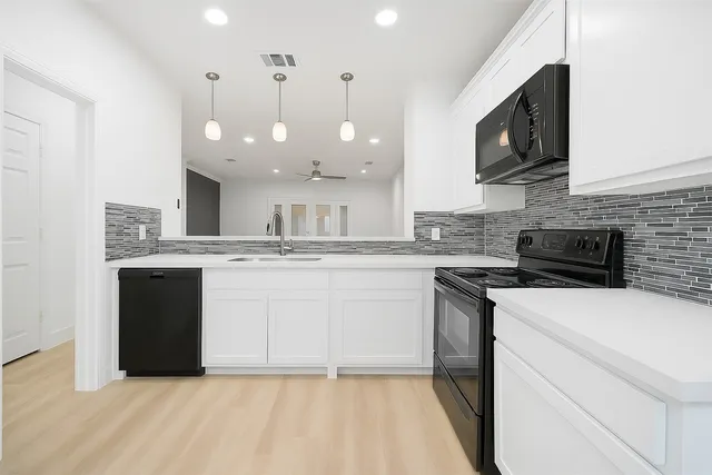 a kitchen with a sink dishwasher a stove top oven a refrigerator with island and cabinets