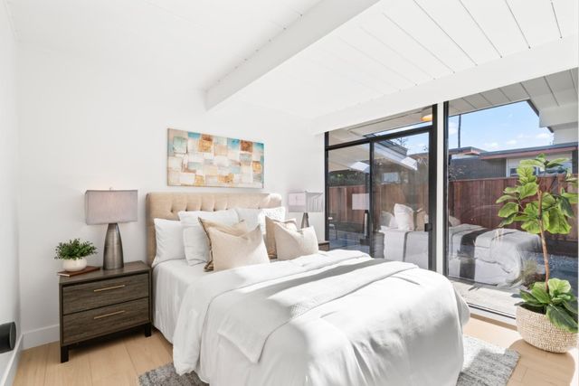 a bedroom with a bed and a painting on the wall