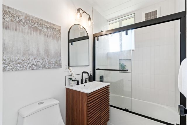 a bathroom with a sink mirror vanity and toilet