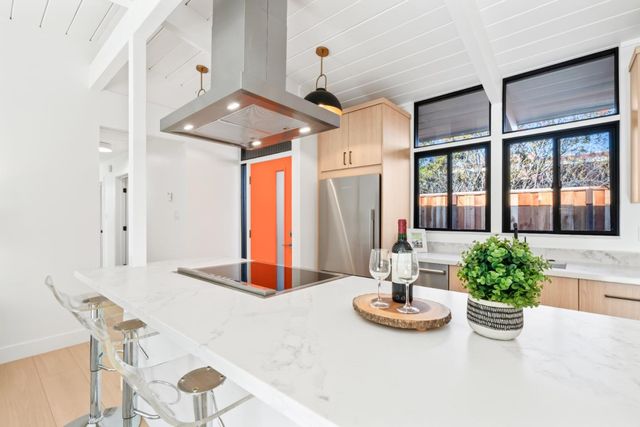 a large kitchen with kitchen island white cabinets and wooden floors