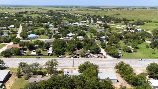 an aerial view of residential houses with outdoor space and trees