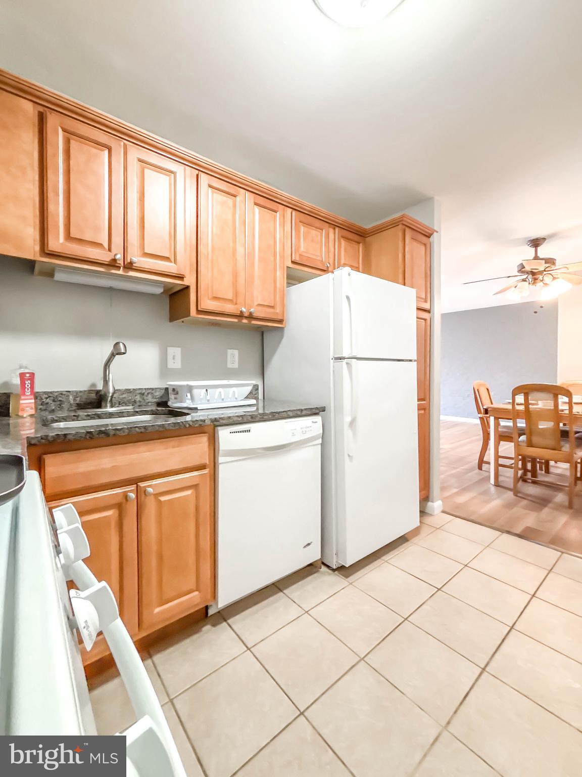 130 Slade Avenue, Unit 414 Baltimore, MD 21208 - Photo 36 of 48 a kitchen with a refrigerator a stove a sink and cabinets