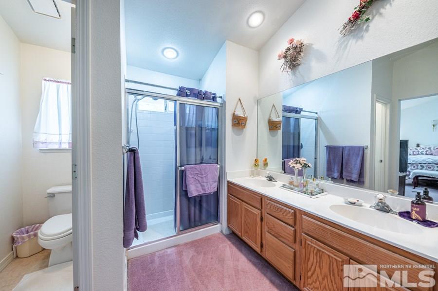 3930 Aspendale Drive Reno, NV 89503 - Photo 16 of 26 a spacious bathroom with a double vanity sink toilet mirror and shower