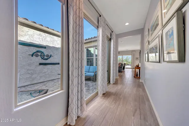 a view of a hallway with wooden floor and a living room