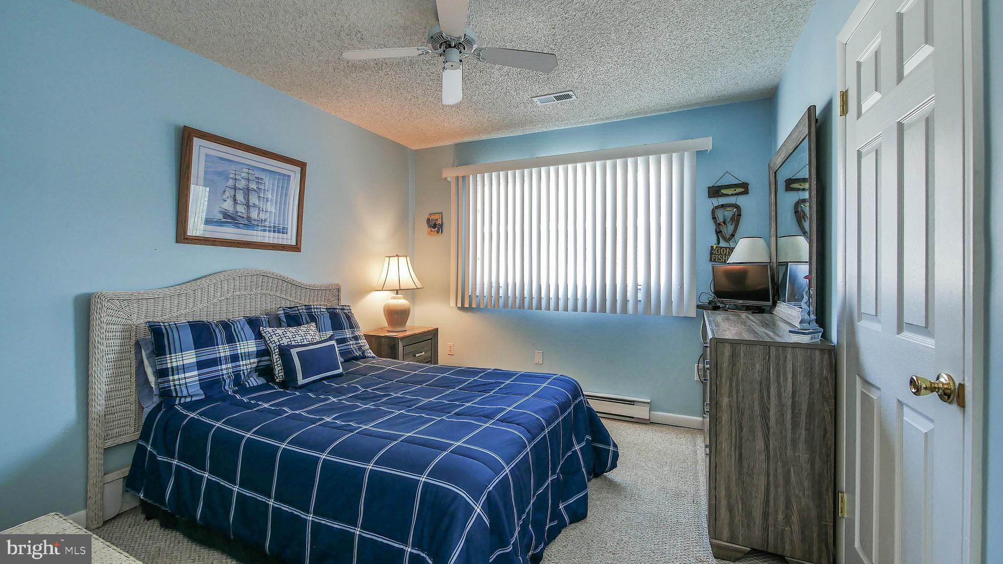 4025 4th Avenue Avalon, NJ 08202 - Photo 12 of 32 a bedroom with a bed and a lamp