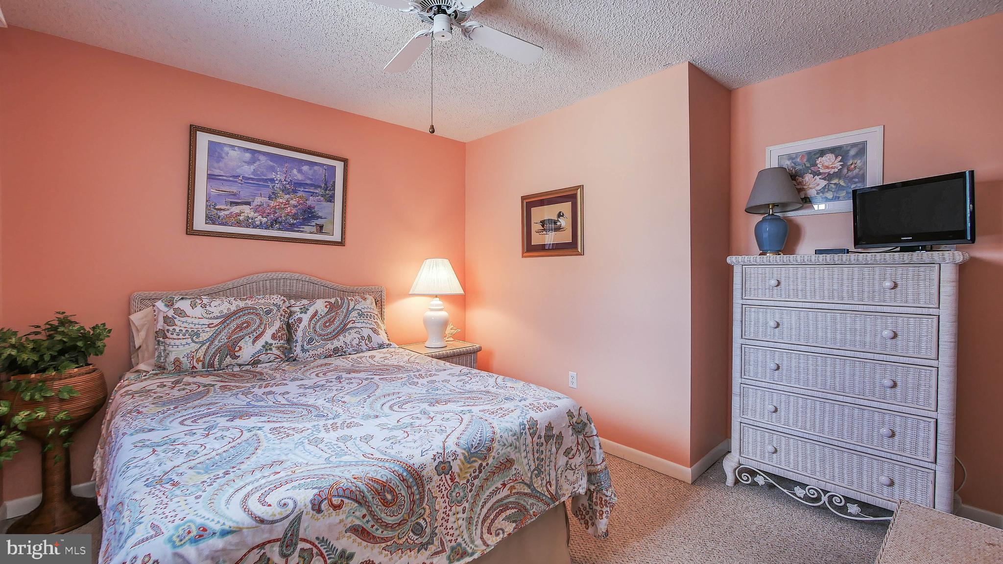 4025 4th Avenue Avalon, NJ 08202 - Photo 15 of 32 a bedroom with a large bed and a flat screen tv