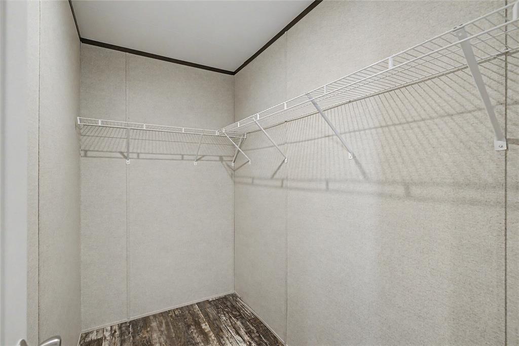 177 New Highland Road Springtown, TX 76082 - Photo 24 of 40 Walk-in closet featuring wire shelving, wood-finish flooring, and light-toned wall panels