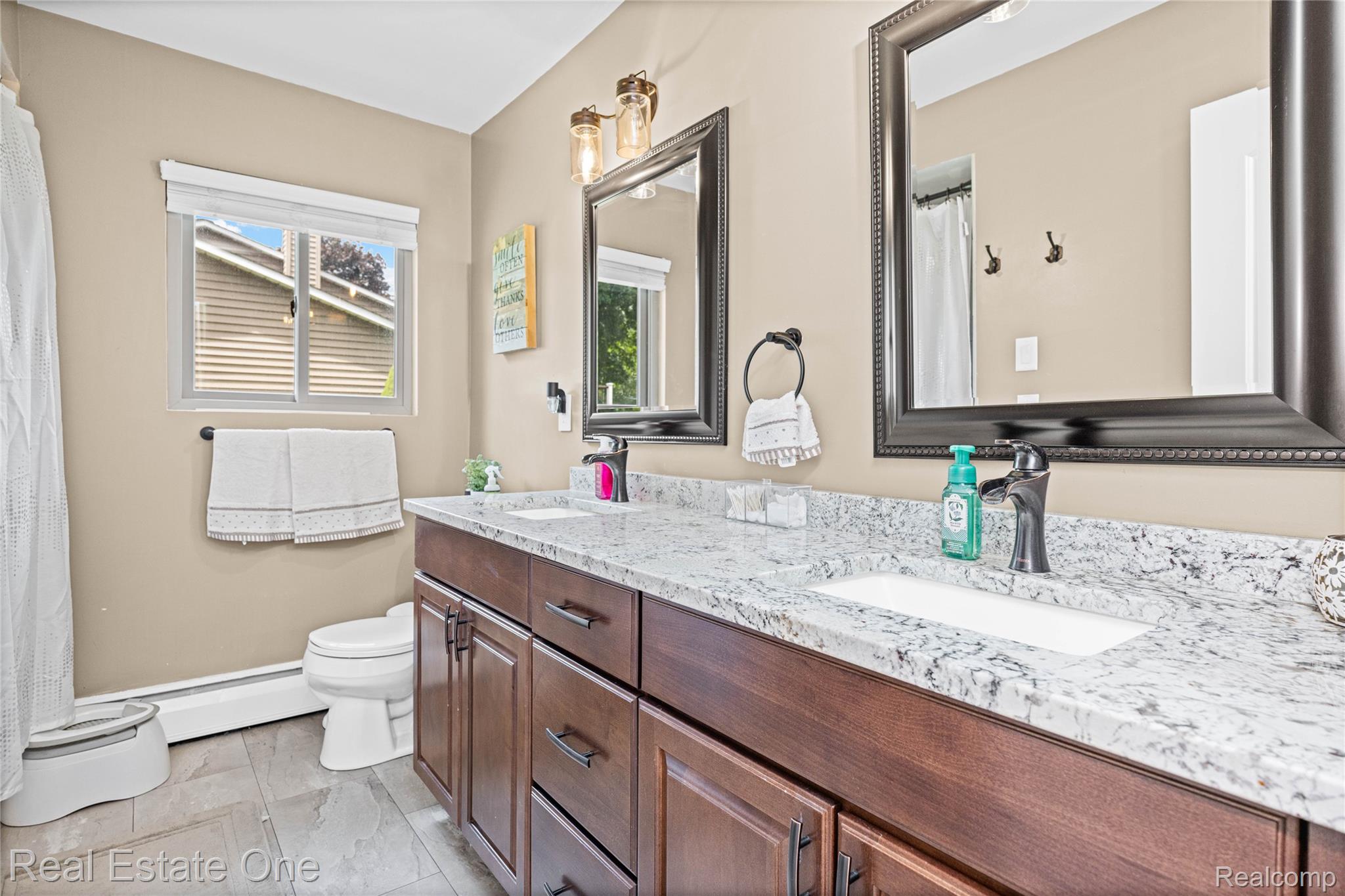 2810 Walbridge Drive Rochester, MI 48307 - Photo 29 of 58 Dual vanity featuring an integrated sink with a black faucet, a speckled countertop, and wood-finish cabinetry