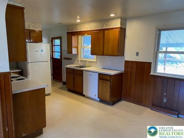 a kitchen with stainless steel appliances granite countertop a refrigerator a stove a sink and a microwave