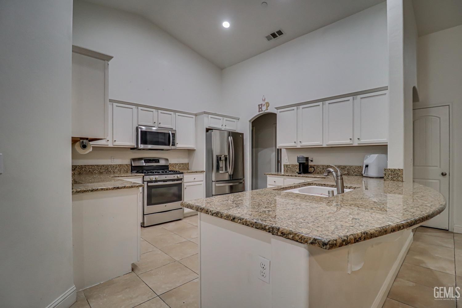 Undisclosed Address Bakersfield, CA 93313 - Photo 11 of 25 a kitchen with stainless steel appliances granite countertop a sink dishwasher stove and refrigerator
