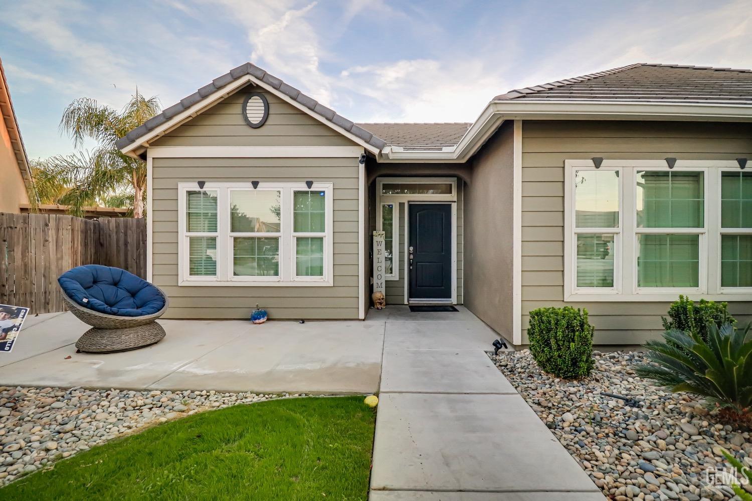 Undisclosed Address Bakersfield, CA 93313 - Photo 4 of 25 a front view of a house with a yard and potted plants