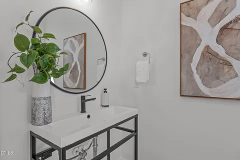 a bathroom with a sink a mirror and a fan