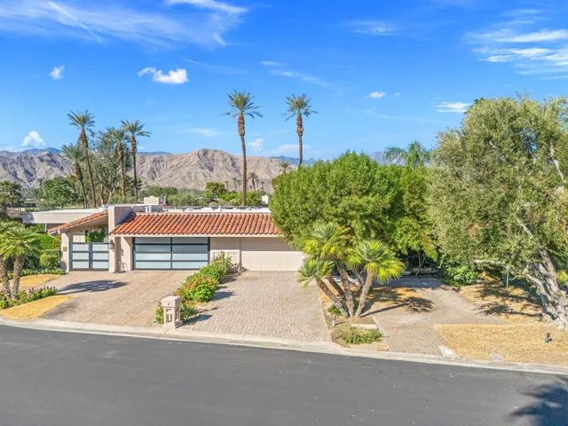 a view of a patio with couple of chairs and potted plants