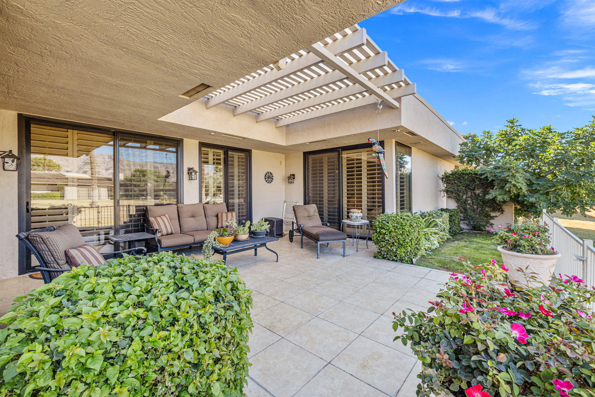 10 Whittier Court Rancho Mirage, CA 92270 - Photo 26 of 88 a view of a patio with table and chairs potted plants with wooden floor and fence