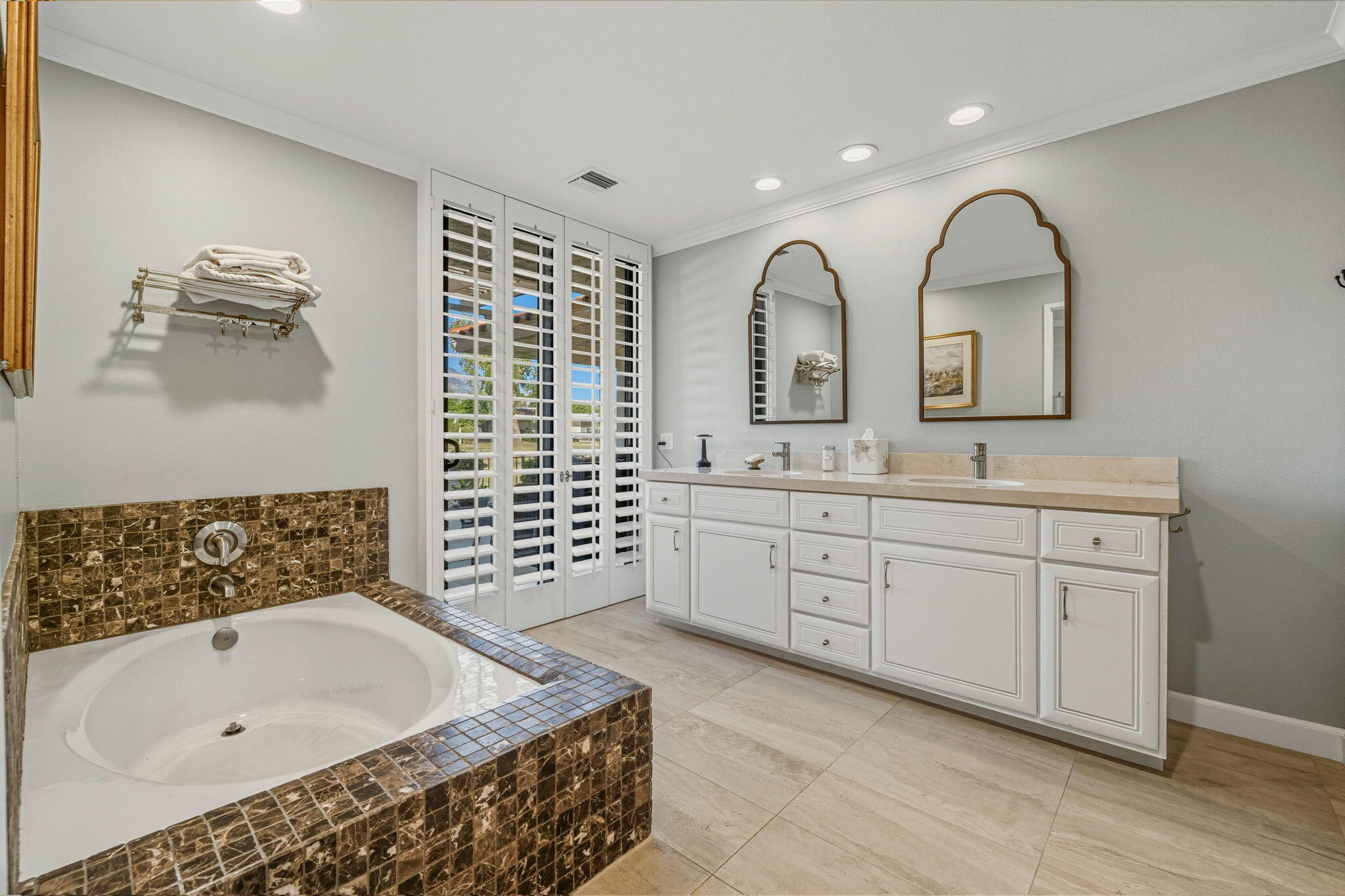 10 Whittier Court Rancho Mirage, CA 92270 - Photo 61 of 88 a spacious bathroom with a granite countertop sink a mirror a window and a bathtub