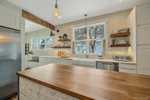 a kitchen with stainless steel appliances wooden floor and large window
