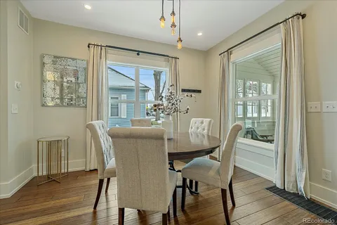 a dining room with furniture a chandelier and wooden floor