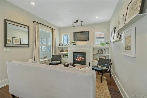a living room with furniture a fireplace and a flat screen tv