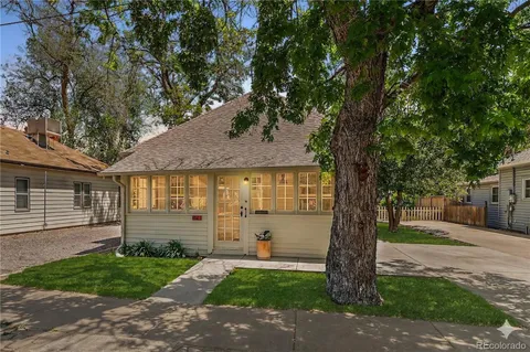 a front view of a house with a yard and an tree