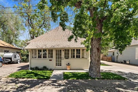 a view of a backyard with wooden fence and a large tree