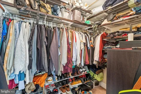 a view of walk in closet with clothes