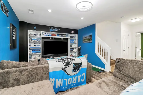 a living room with furniture a flat screen tv and a table