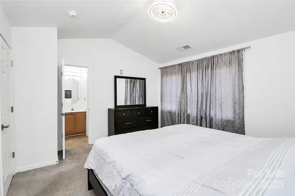 a large bed in a white room with closet and dresser