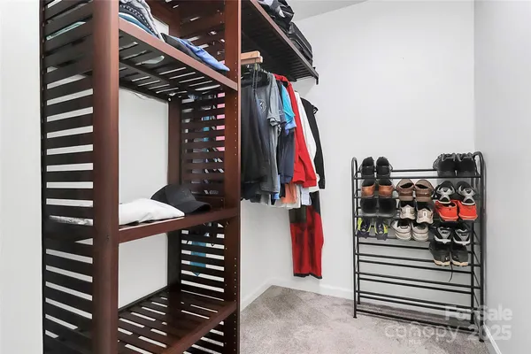 a view of walk in closet with clothes and shoes