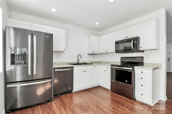 a kitchen with stainless steel appliances granite countertop a refrigerator stove and sink