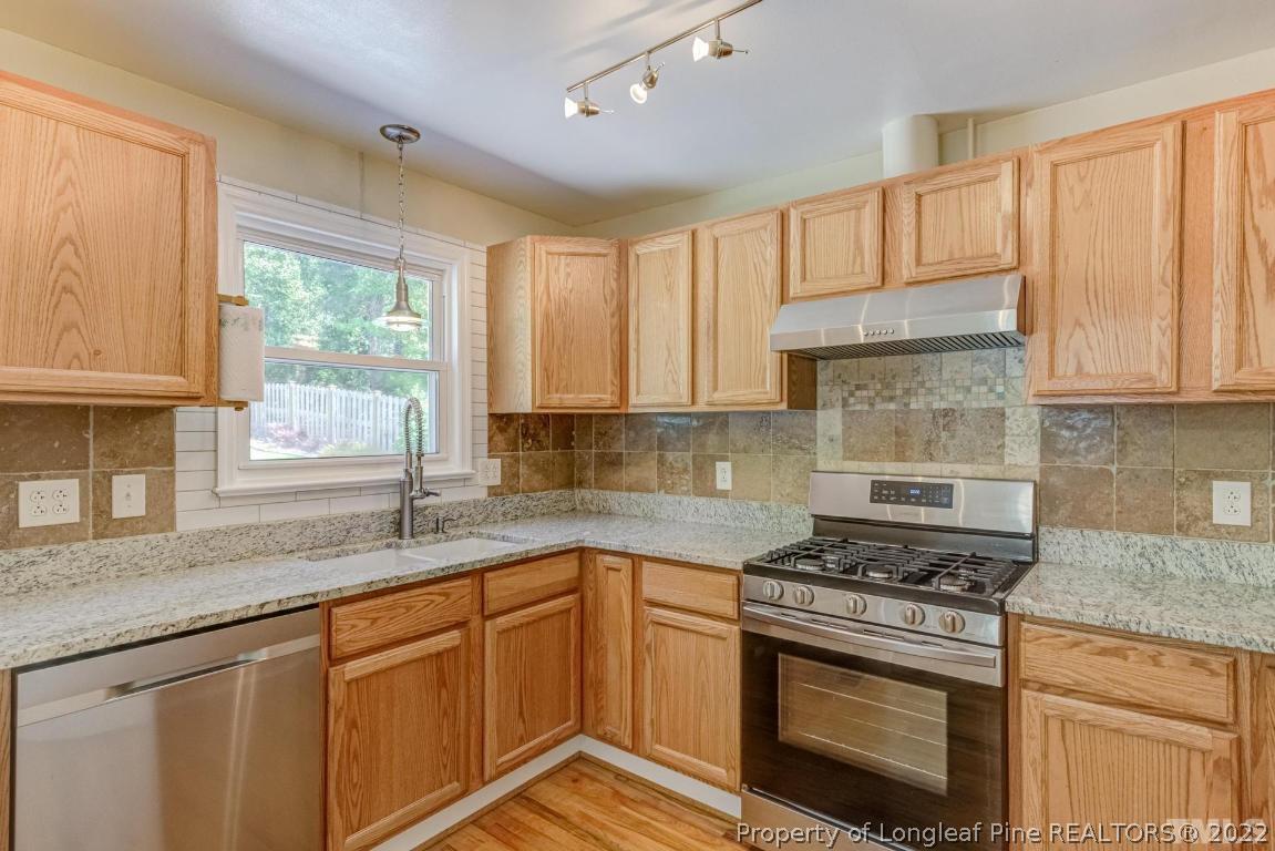 2710 Broad Street Durham, NC 27704 - Photo 14 of 36 a kitchen with granite countertop white cabinets and a window