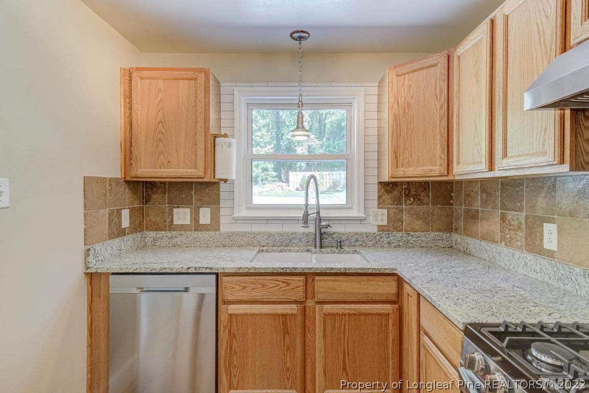 2710 Broad Street Durham, NC 27704 - Photo 15 of 36 a kitchen with granite countertop cabinets sink and window