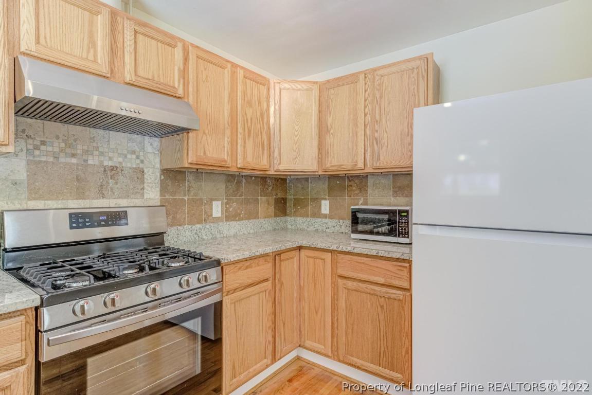 2710 Broad Street Durham, NC 27704 - Photo 18 of 36 a kitchen with a stove a refrigerator and a sink