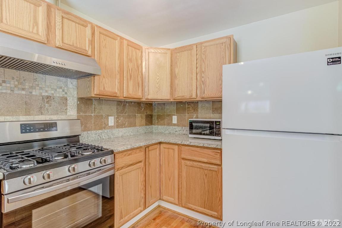 2710 Broad Street Durham, NC 27704 - Photo 19 of 36 a kitchen with a stove a refrigerator and a sink