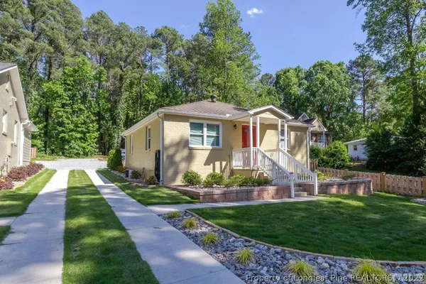 a front view of a house with a yard and potted plants