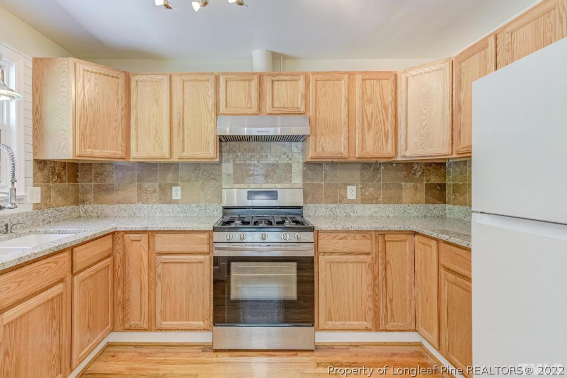 2710 Broad Street Durham, NC 27704 - Photo 21 of 36 a kitchen with a stove a sink and a microwave