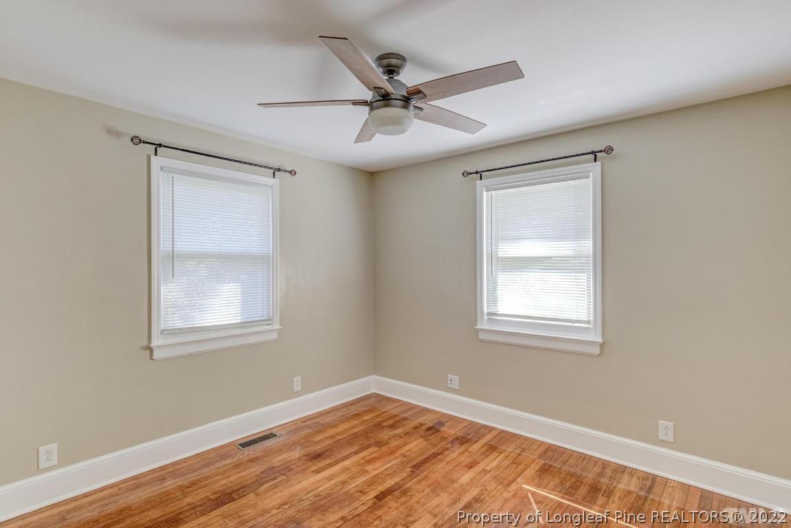 2710 Broad Street Durham, NC 27704 - Photo 23 of 36 an empty room with wooden floor windows and fan