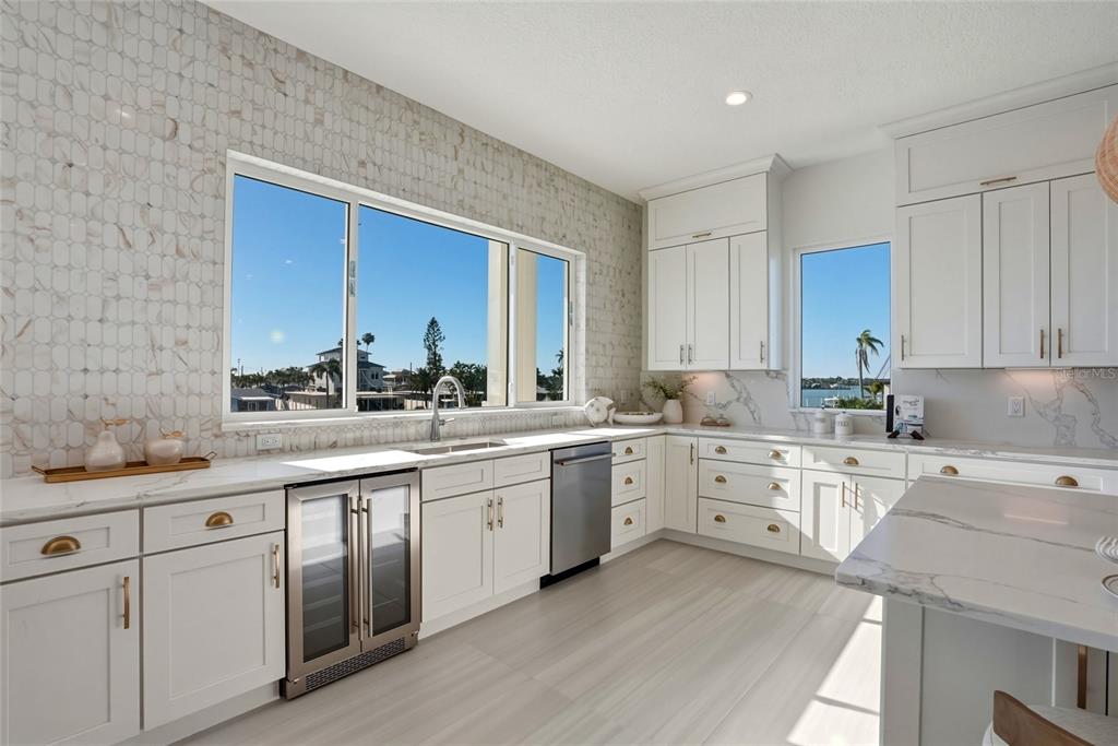 534 Crystal Drive Madeira Beach, FL 33708 - Photo 10 of 68 a kitchen with white cabinets sink and stove