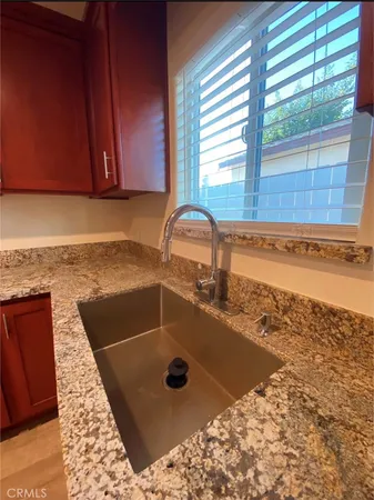 a bathroom with a granite countertop sink and a window