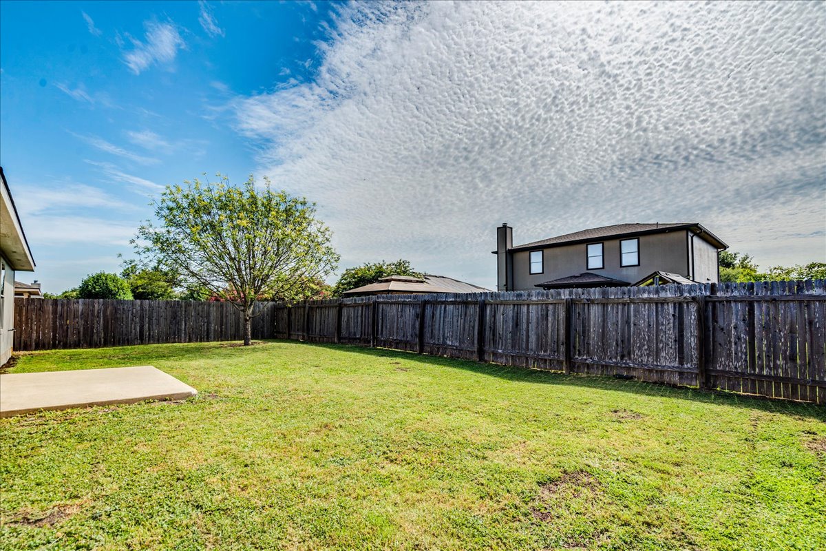 100 Easy Street Hutto, TX 78634 - Photo 30 of 36 A secluded backyard sanctuary with a spacious lawn and private fencing offers ample outdoor living.