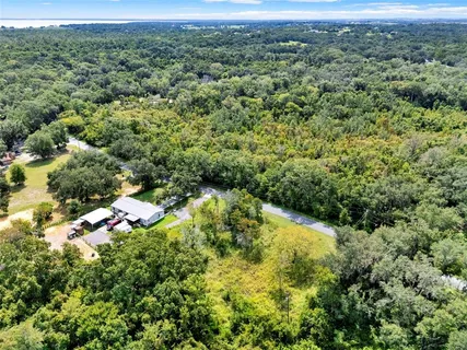 a view of a green yard with an and white house