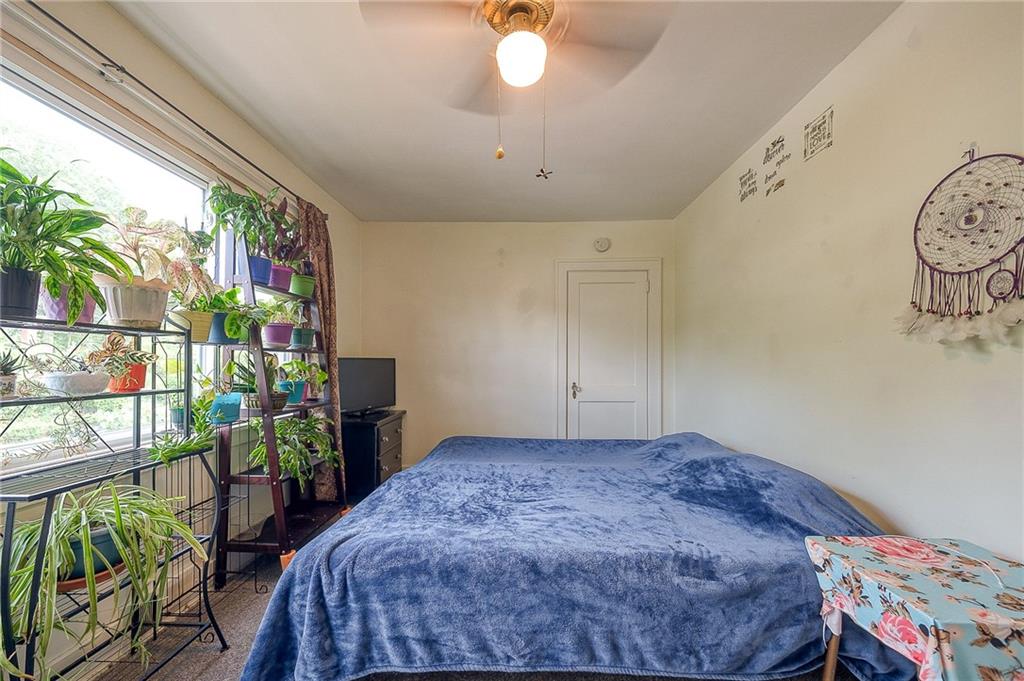 120 Duffield Avenue Pittsburgh, PA 15235 - Photo 13 of 21 a bedroom with a bed a chandelier and a window