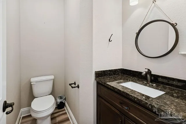 a bathroom with a granite countertop toilet and a sink