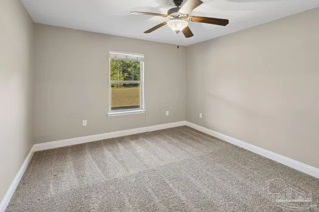 an empty room with a window and a fan