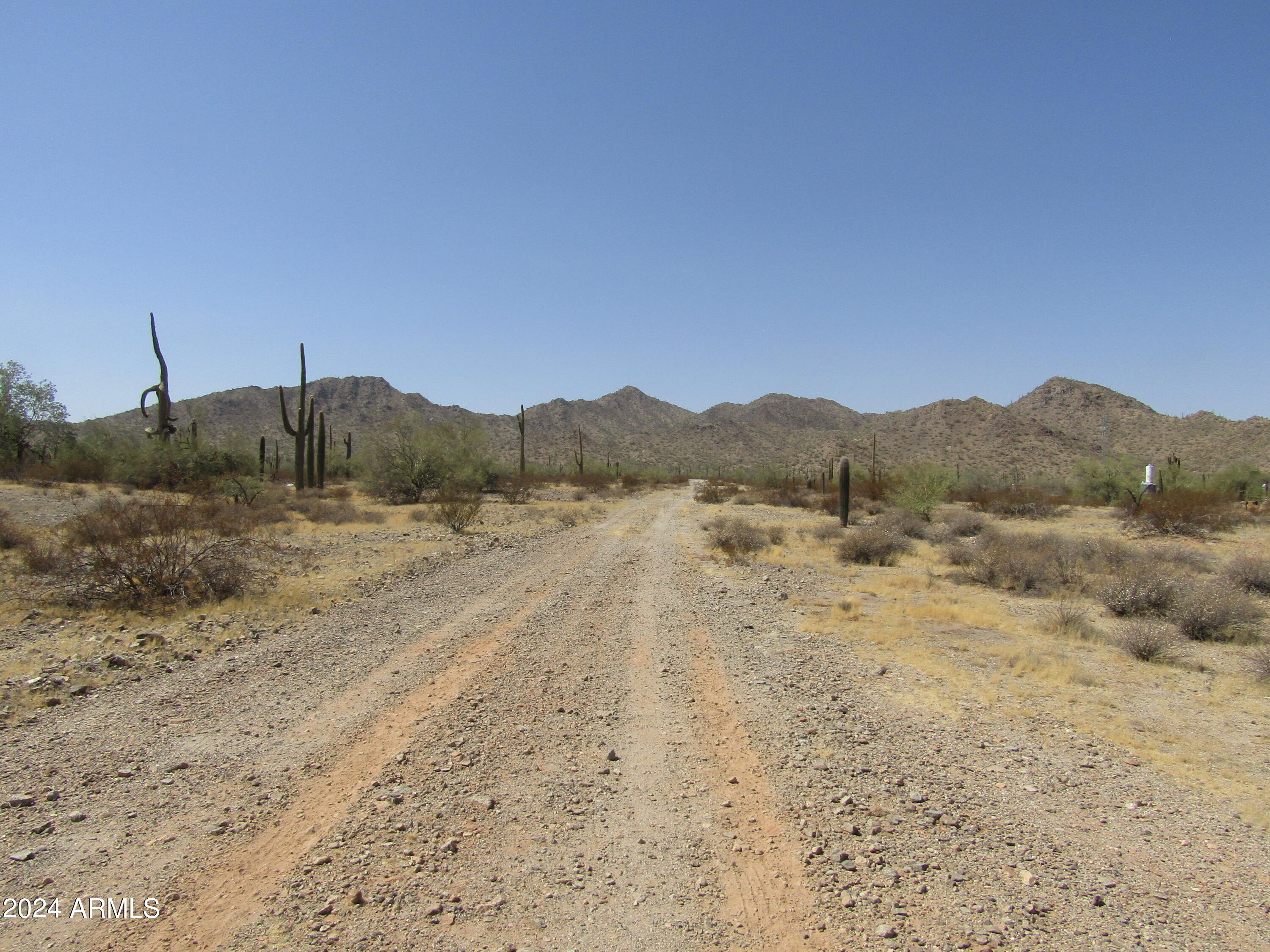 0 West Momoli Road, Unit 24 Maricopa, AZ 85139 - Photo 8 of 11 a view of a dry field with mountains in the background