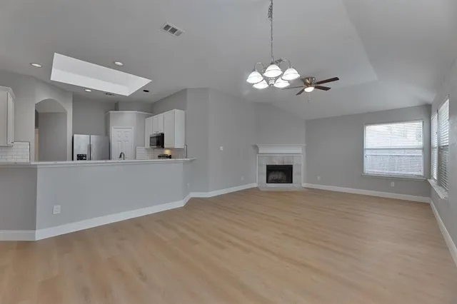 a view of kitchen with refrigerator and wooden floor