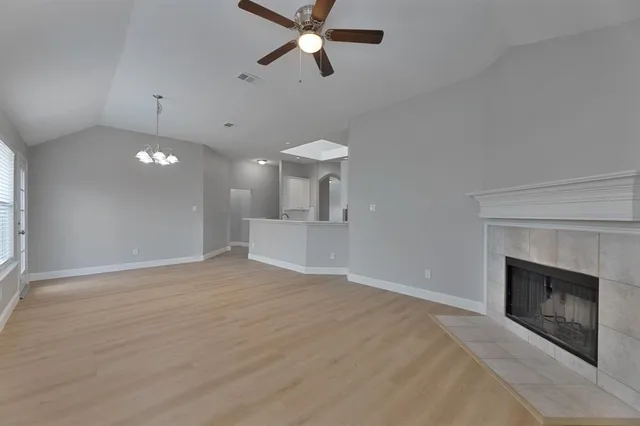a view of an empty room with a kitchen and a window