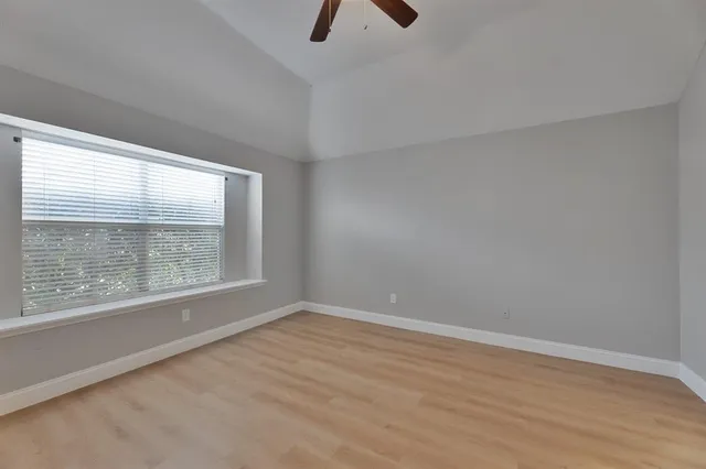 a view of an empty room with a fireplace and window