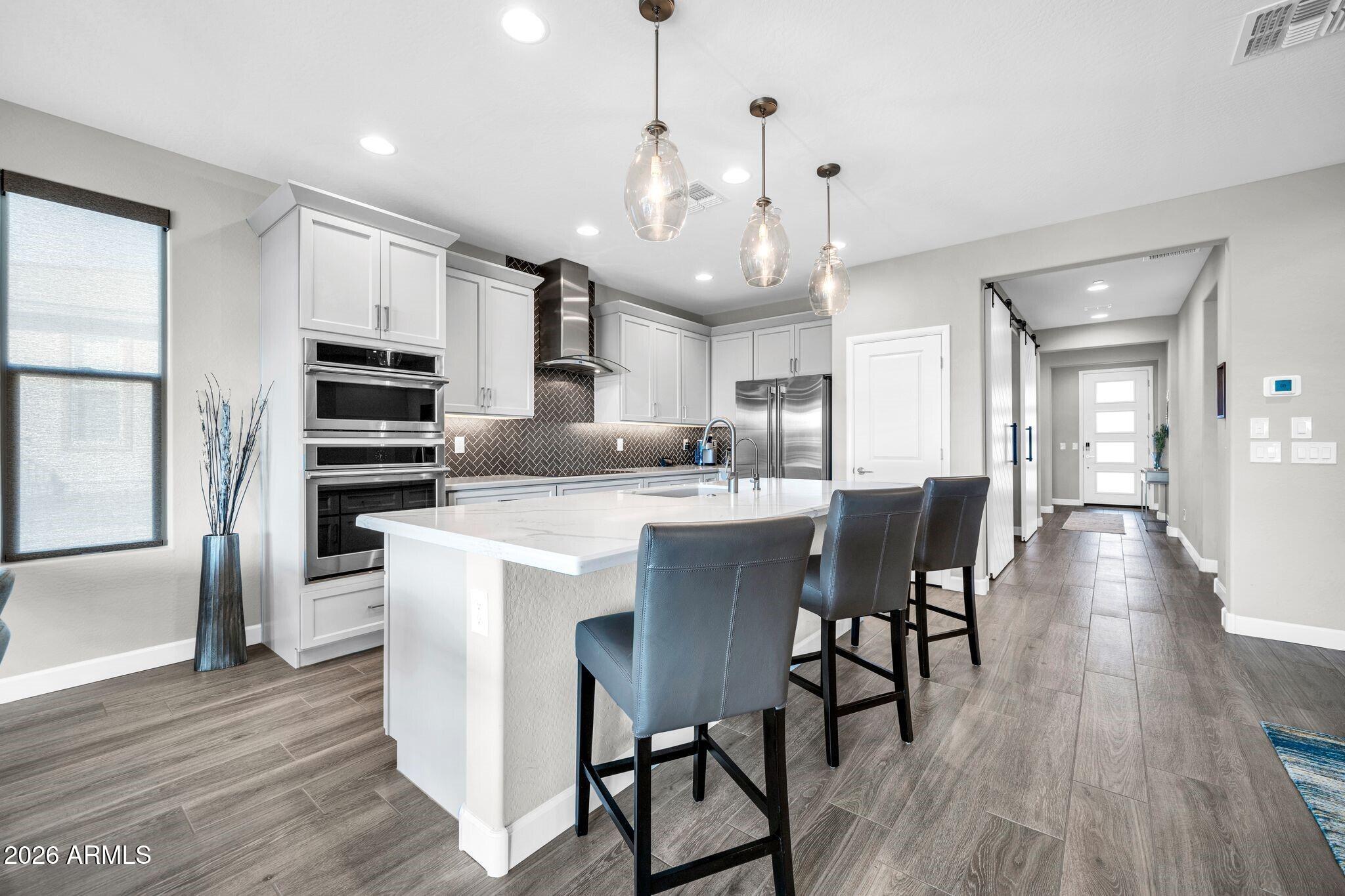 17501 East Cindercone Road Rio Verde, AZ 85263 - Photo 5 of 43 a kitchen with stainless steel appliances kitchen island granite countertop a table chairs and a refrigerator